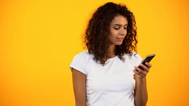 Meraklı Afrikalı-Amerikalı kadın akıllı telefon kullanarak, modern teknoloji incelemesi