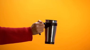 Lady sarı arka plan üzerinde termos gösteren, hizmet götürmek, geri dönüşüm sorunu