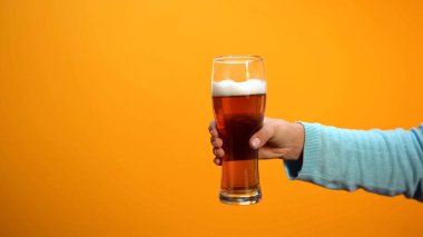 Kadın el sarı arka plan üzerinde bira cam gösteren, pub müşterileri davet