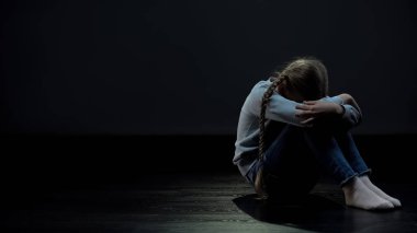 Üzgün kız karanlık odada oturan, zorbalık veya depresyon kavramı, yalnızlık