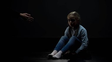 Karanlık odada kadın çocuk yetişkin yardım eli, sosyal güvenlik kavramı bakıyor