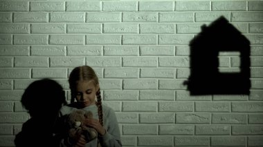 Ne yazık ki ev gölge üzerinde seyir ve oyuncak ayı, evsiz sarılma küçük kız