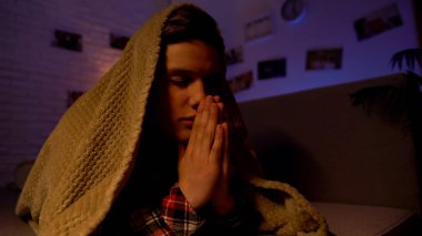 Religious teenager praying covered with blanket, belief in god, sectarianism clipart