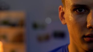 Spor salonunda yoğun egzersiz sonrası kameraya bakan ciddi genç adam, yarı yüz