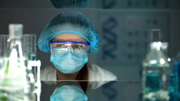 实验室工作人员在保护眼镜和统一看化学试剂 — 图库照片