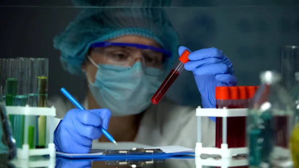 医師が血液分析でチューブをチェックし メモを作る リンパ腫癌 — ストック写真