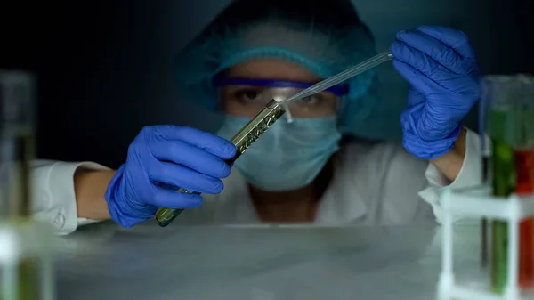 ラボアシスタント透明な黄色の物質で試験管に油性の液体を追加 — ストック写真