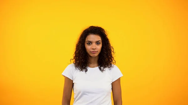 年轻的非洲裔美国女人看着被黄色背景隔离的相机 — 图库照片