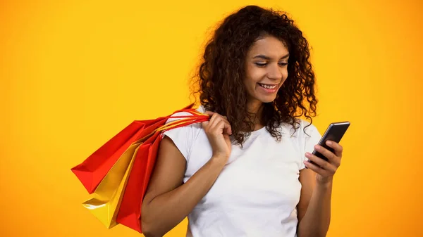 Uśmiechnięta Afro Amerykańska Kobieta Trzyma Torby Zakupy Smartphone Sklep Internetowy — Zdjęcie stockowe