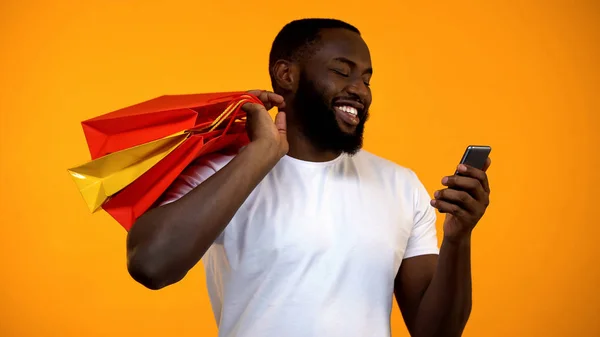 Ευτυχισμένος Άνθρωπος Αφροαμερικάνικης Κρατώντας Τσάντες Για Ψώνια Και Smartphone Ηλεκτρονική — Φωτογραφία Αρχείου