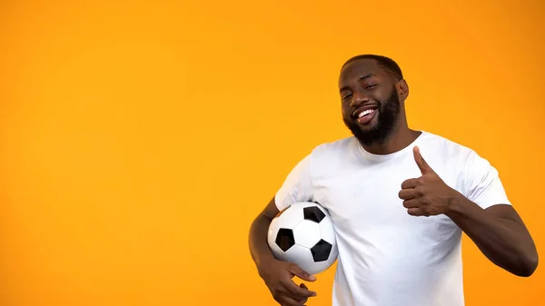Attraktiver Afroamerikanischer Mann Hält Fußballball Und Zeigt Daumen Hoch — Stockfoto