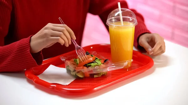 穿着红色毛衣的女人在自助餐厅里吃蔬菜沙拉 在桌子上喝橙汁 — 图库照片