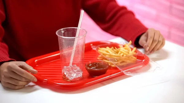 在快餐店吃午饭的女人 薯条和盘子里的空杯子 — 图库照片