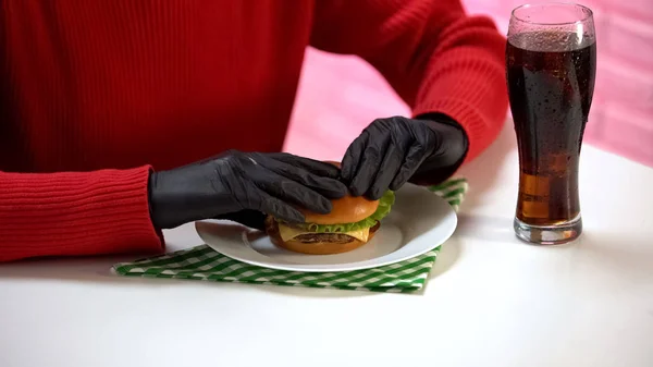 Vrouwelijke Zwarte Rubberen Handschoenen Houden Van Smakelijke Hamburger Drinken Soda — Stockfoto