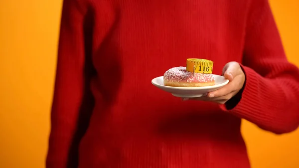 ドーナツと測定テープ 不健康な食事 肥満リスクを持つ女性の保持プレート — ストック写真