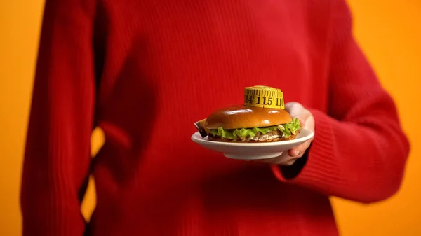 Vrouwelijke Holding Plaat Met Hamburger Meetlint Ongezonde Voeding Dieet — Stockfoto