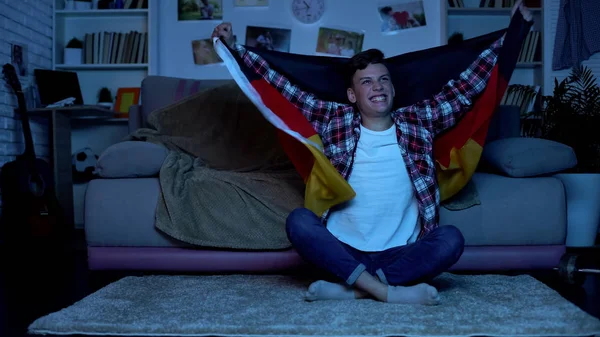 College student holding German flag, supporting national football team, sport