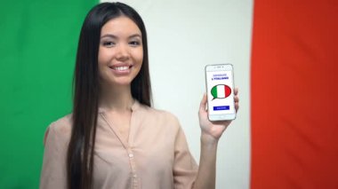 Dil çalışması uygulaması ile telefon tutan kadın öğrenci, arka planda Italyan bayrağı