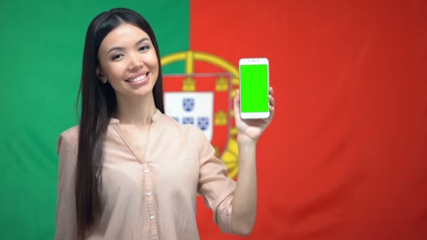Mujer mostrando el teléfono con pantalla verde, bandera alemana en el fondo, aplicación de viaje — Vídeo de stock