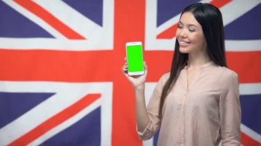 Arka planda Ingiliz bayrağı karşı yeşil ekran ile telefon gösteren Lady, uygulama