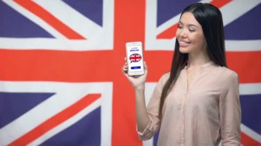 Kız tutan telefon Ingilizce uygulama, arka planda bayrak, eğitim öğrenmek