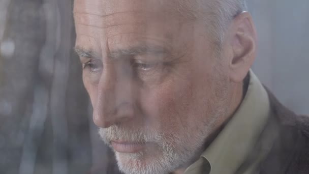 Несчастный пожилой человек смотрит в камеру тяжело вздохнувший, беззащитный бедный пенсионер — стоковое видео