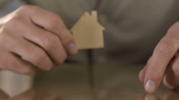 Ώριμος άνθρωπος κρατώντας ξύλινο σχήμα του σπιτιού πριν από την κάμερα, λείπει το σπίτι σε άσυλο — Αρχείο Βίντεο