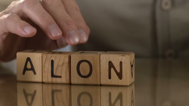 Поодинці, зрілий чоловік робить слово з дерев'яних кубиків, самотні люди в будинку престарілих — стокове відео