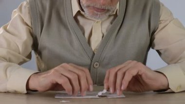 Evde yapboz birleştirerek Kıdemli adam, mantıksal düşünme geliştirme