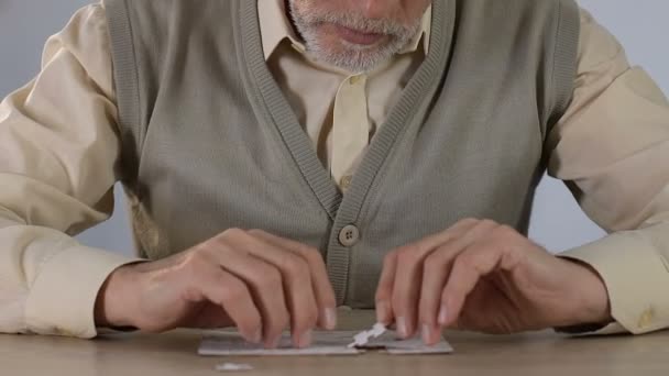 Uomo anziano che unisce puzzle a casa, sviluppo del pensiero logico — Video Stock