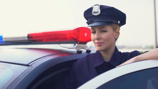 Bella signora poliziotto in berretto di servizio sorridente alla macchina fotografica, donna che protegge la città — Video Stock