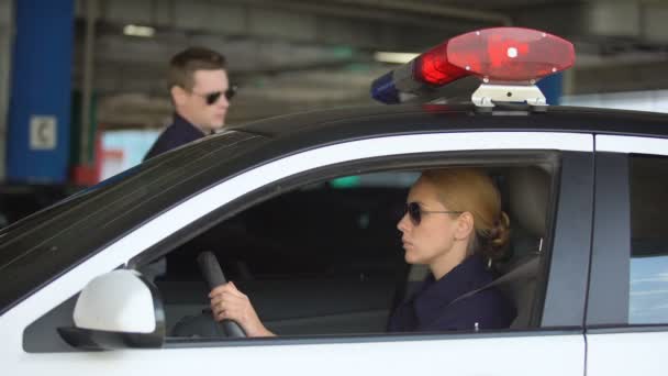 Hombre policía sentado en coche patrulla a su pareja femenina y que conduce a llamar — Vídeos de Stock