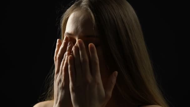 Genç kadın yüz boynunu okşayarak ve aşağı bakıyor, güvensizlikile mücadele — Stok video