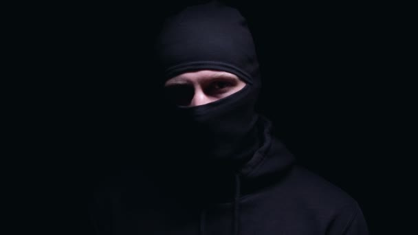 Assassino louco tocando seu rosto mascarado com uma faca grande, ameaçando de assassinato — Vídeo de Stock