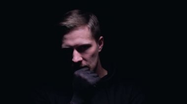 Eldivenli deli adam çenesine dokunup gülümsüyor, kanlı cinayet planlıyor.