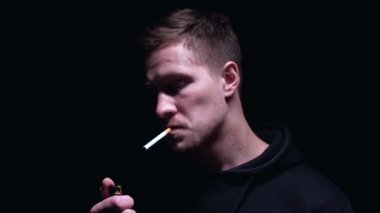 Yüzünde korkunç bir sırıtışla sigara içen adam, suç planlama, yakın çekim