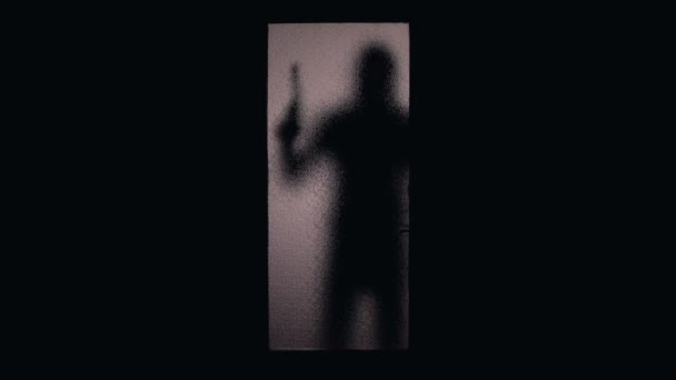 戴头罩的罪犯瞄准玻璃门的枪剪影，合同杀人犯罪 — 图库视频影像