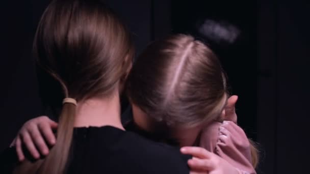 Mother hugging frightened little girl in dark room, victims of mafia, kidnapping — Stock Video