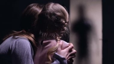 Panik kapılmış kadın ve çocuk kapının dışında korkunç canavar siluet izliyor