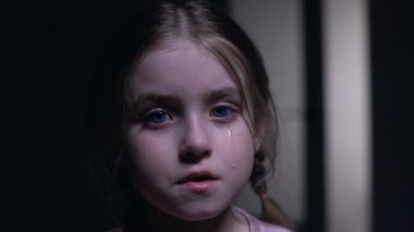 Kameraya bakan küçük ağlayan kız, aile içi şiddet kurbanı, çocuk hakları