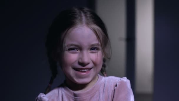 Милая маленькая девочка смеется в камеру, искренние детские эмоции, крупный план — стоковое видео