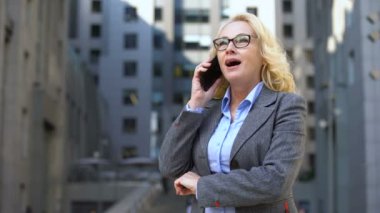 Telefonda konuşurken evet jestgösteren yaşlı kadın emlakçı, iş anlaşması onayı