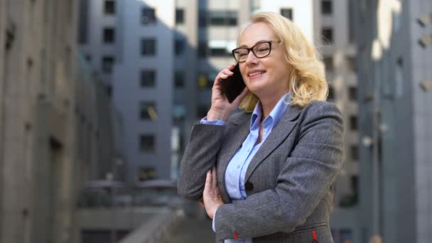 Alegre mujer gerente hablando por teléfono de pie fuera, comunicación con el cliente — Vídeos de Stock