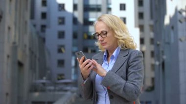 Akıllı telefon uygulaması, haberci kullanarak başarı jesti gösteren yaşlı bayan patron