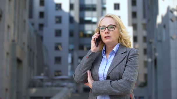 Senior female boss feeling angry and disappointed talking on phone, failure — Stock Video