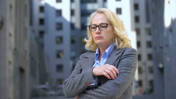 Pensive female director in eyeglasses standing outdoors, work stress, anxiety — Stock Video