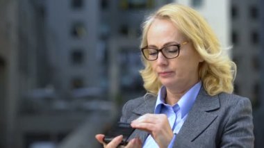 El aynasında göz kırışıklıkları bakarak Üzgün iş kadını, anti-aging kozmetik