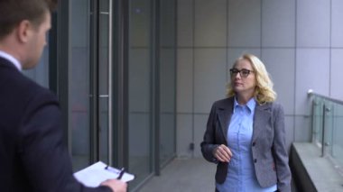 Erkek asistan kıdemli kadın patrondan belgeleri, şirket evraklarını imzalamasını istiyor.