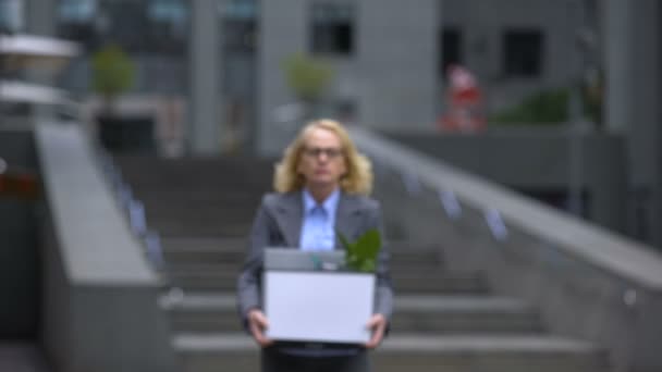 Aged woman with stuff box leaving office building, pension age, work opportunity — Stock Video