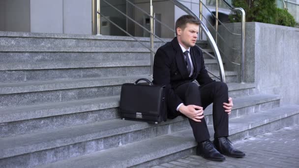 Sad man in business suit sitting office building stairs, dismissal depression — Stock Video